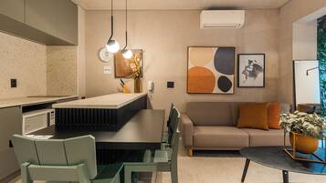 A modern kitchen with a dining area, a sofa, and a coffee table.