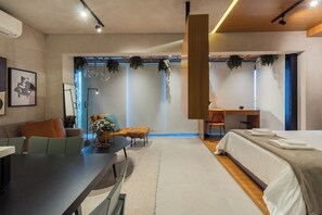Une chambre d’hôtel moderne équipée d’un lit, d’un bureau, d’un canapé et d’un coin repas.