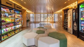 Un interno moderno con ripiani per snack, zone relax e una macchina per bevande.