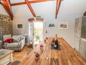 Ein gemütliches Zimmer mit einem Holztisch, der zum Essen gedeckt ist, einer Couch und einer Steinwand.