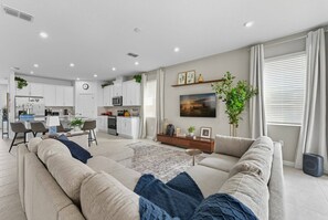 Un salon moderne comprenant un canapé, un coin repas et une cuisine.