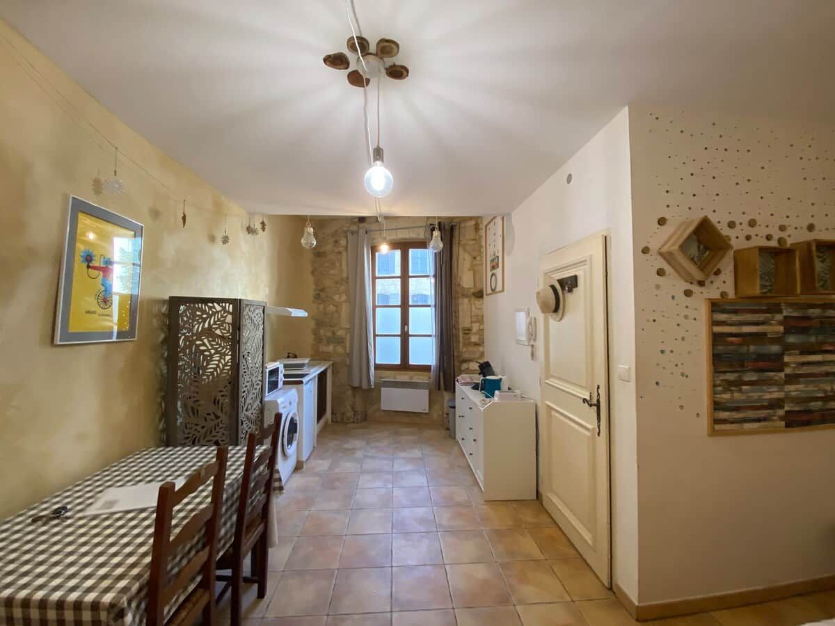 A compact kitchen with a dining area, a washing machine, and a radiator.
