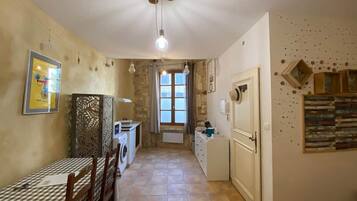 A compact kitchen with a dining area, a washing machine, and a radiator.