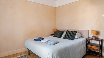 A bedroom with a bed, two bedside tables, and a nightstand.