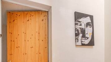 Una puerta de madera, una escalera y una obra de arte colgada en la pared.