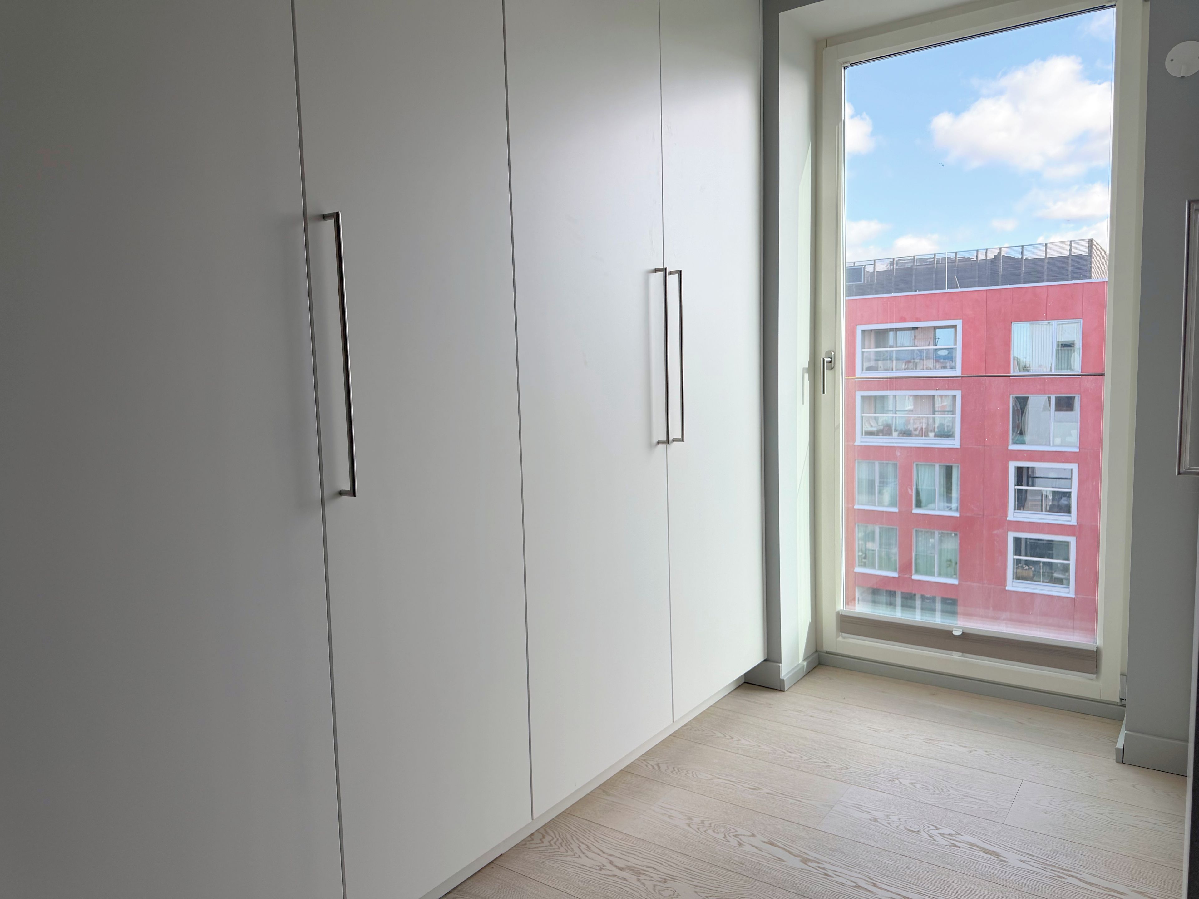 A room with white cabinets and a large window.