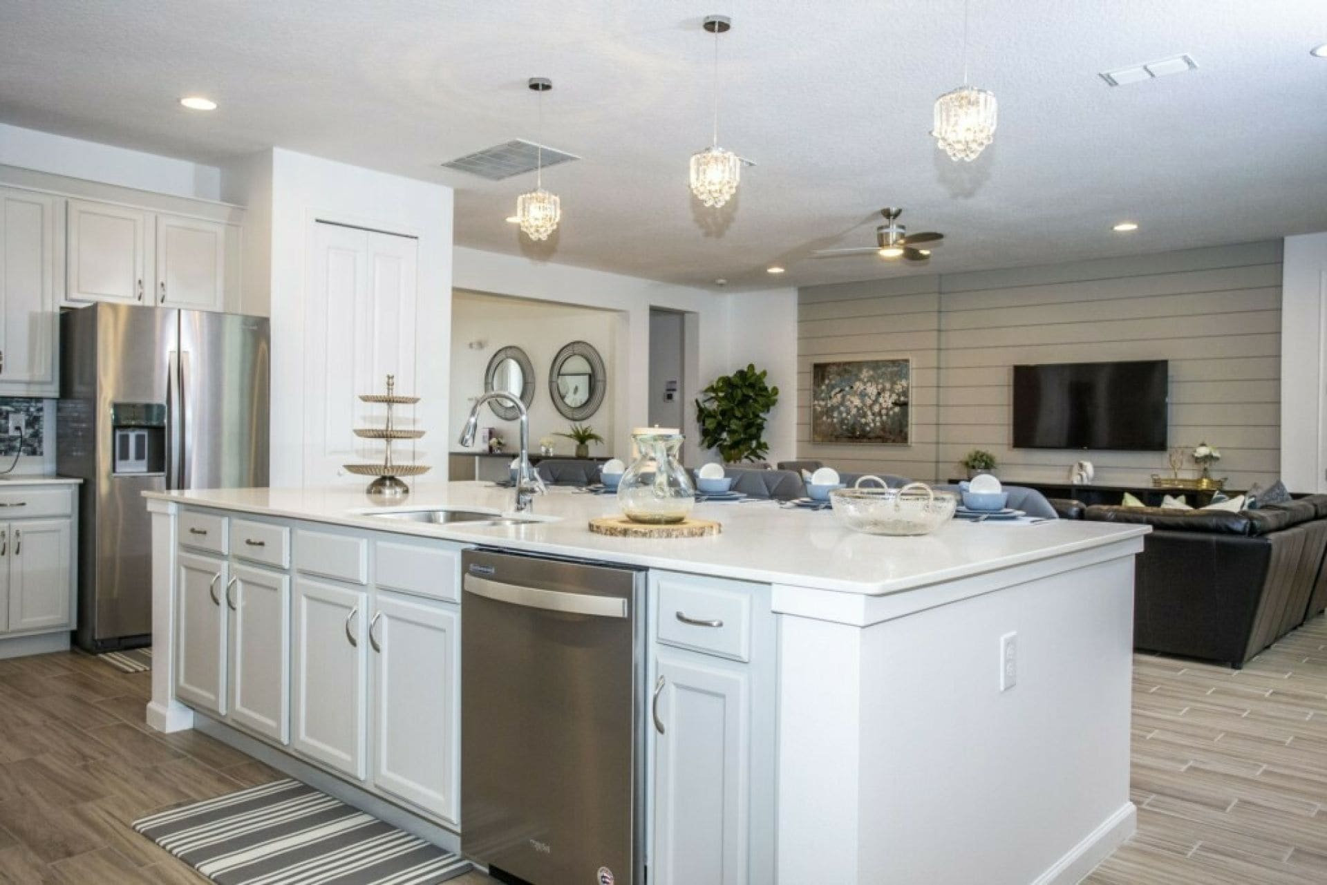 A modern kitchen with a large island, stainless steel appliances, and pendant lighting.