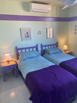 A room with two beds, a ceiling fan, and an air conditioning unit. - Beautiful Beach Front Line Apartment, perfect central location. (Fuengirola)