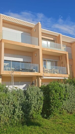 A multi-story residential building with balconies, large windows, and a flat roof. - Sea View Apt in Taghazout - Pool - Surf & Golf (Agadir)