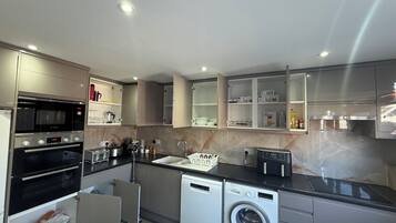 A modern kitchen with built-in appliances, including an oven, microwave, and dishwasher.