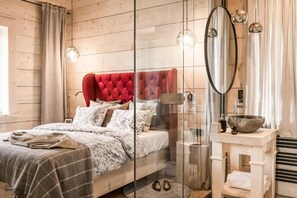A bedroom with a wooden headboard, a bed with a patterned bedspread, a bedside table with a bowl, and a mirror. - Villa Gorsky-Hanco (Poronin)