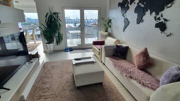 Un salon moderne avec un canapé, une table basse, un téléviseur et une carte du monde accrochée au mur.