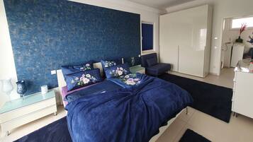 Une chambre à coucher comprenant un lit, une table de chevet, une commode, une chaise et une armoire.