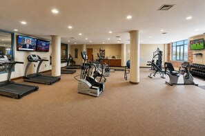 Ein Fitnessstudio mit Laufbändern, Crosstrainern und Gewichtsmaschinen.