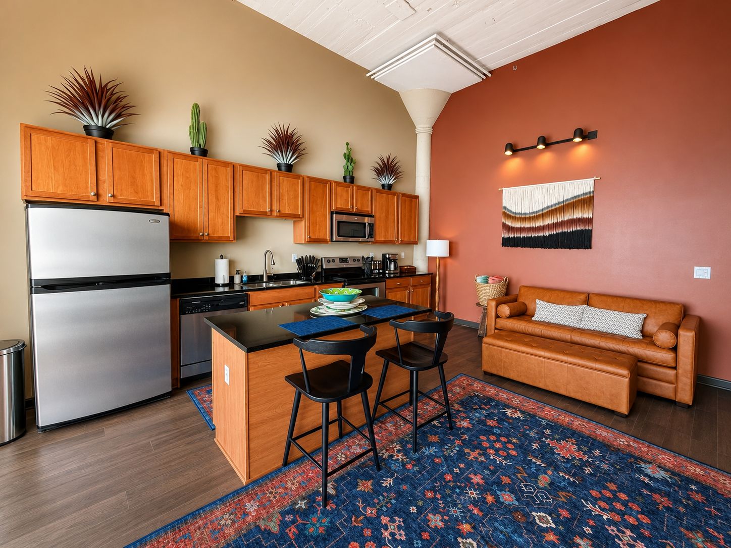 Una cocina moderna con armarios de madera, un refrigerador de acero inoxidable y una isla central con taburetes de bar.