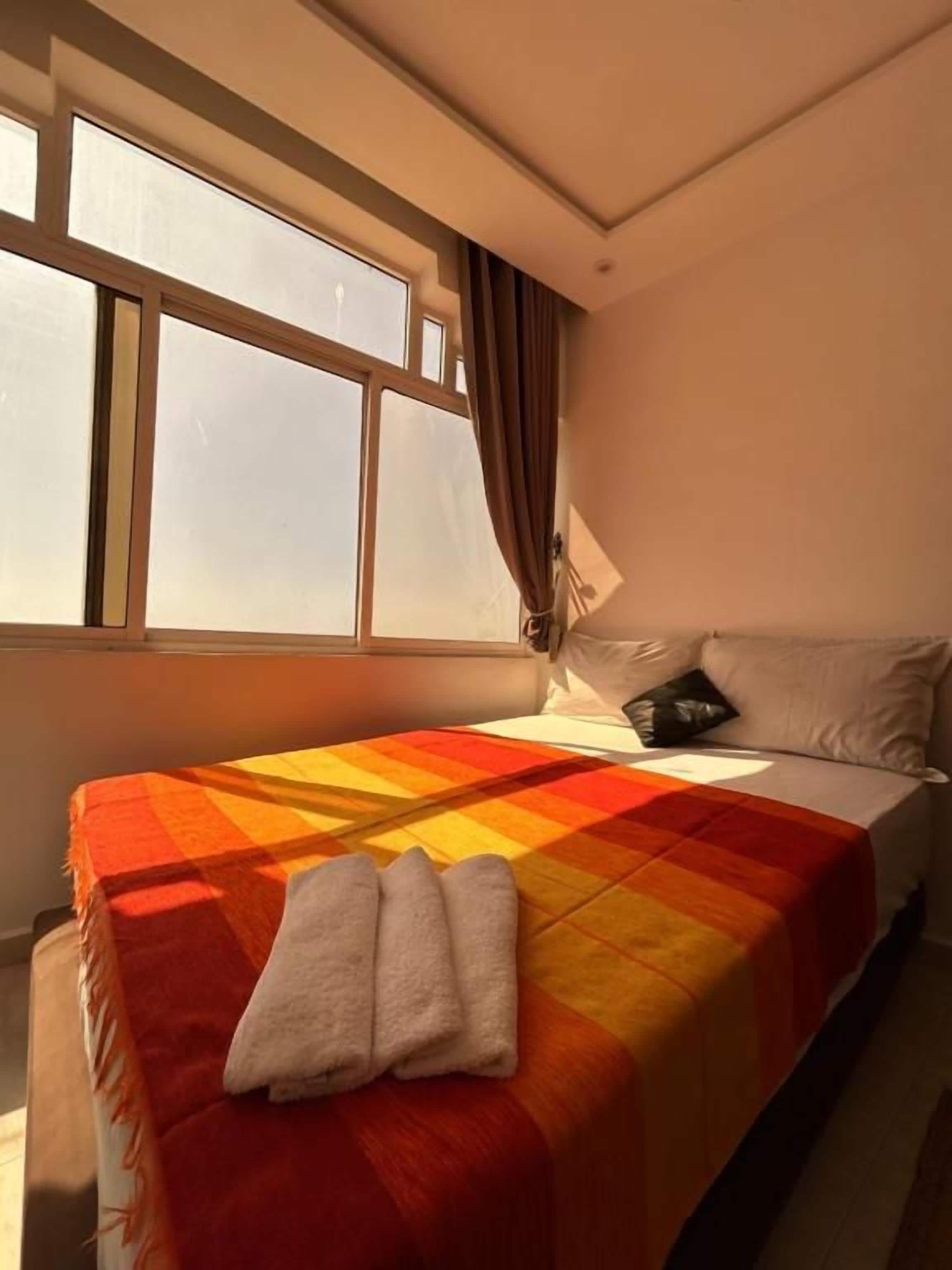 Una habitación de hotel con cama, ventana y vistas al exterior.