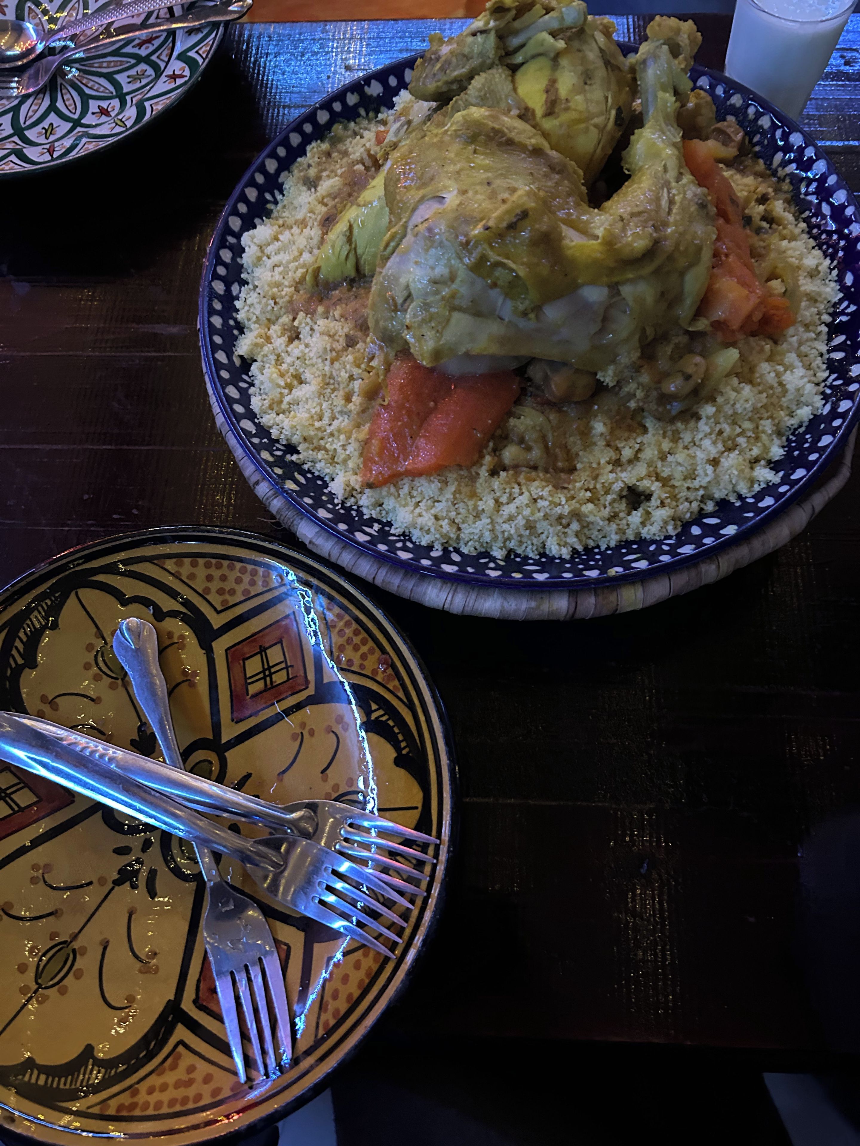 Un plato de comida con un tenedor y una cuchara sobre una mesa.