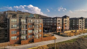 Un immeuble résidentiel à plusieurs étages, doté de balcons, d’une cour intérieure et d’un espace de stationnement.