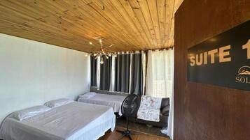 A room with two beds, a ceiling fan, and a sign indicating it's a 'SUITE 1'.