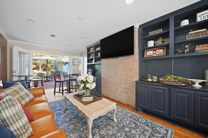 A living room with a sofa, coffee table, and a bookshelf. - Reveille Roundabout: An Aggie Gathering Place 5 min from Kyle Field Sleeps 27 (Bryan)