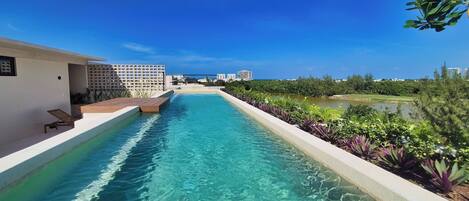 A clear swimming pool with a view of a cityscape in the background.
