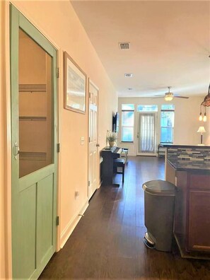 A hallway leading to a dining area with a trash bin and a kitchen island. - Cozy 3-bedroom house 5 min drive to the beach (Panama City Beach)