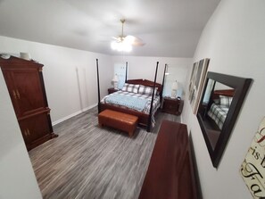 A bedroom with a four-poster bed, a wooden wardrobe, a bench, a ceiling fan, and a mirror on the wall. - Spacious 3 bedroom 2 bath house near Military Bases (Converse)