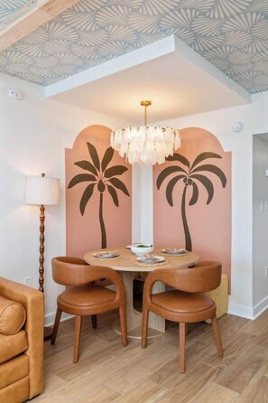 A dining area with a round table, two chairs, and a chandelier. - Oceanfront Pierlight Studio w/VR & Minibar at Yachtsman S1103 (Myrtle Beach)