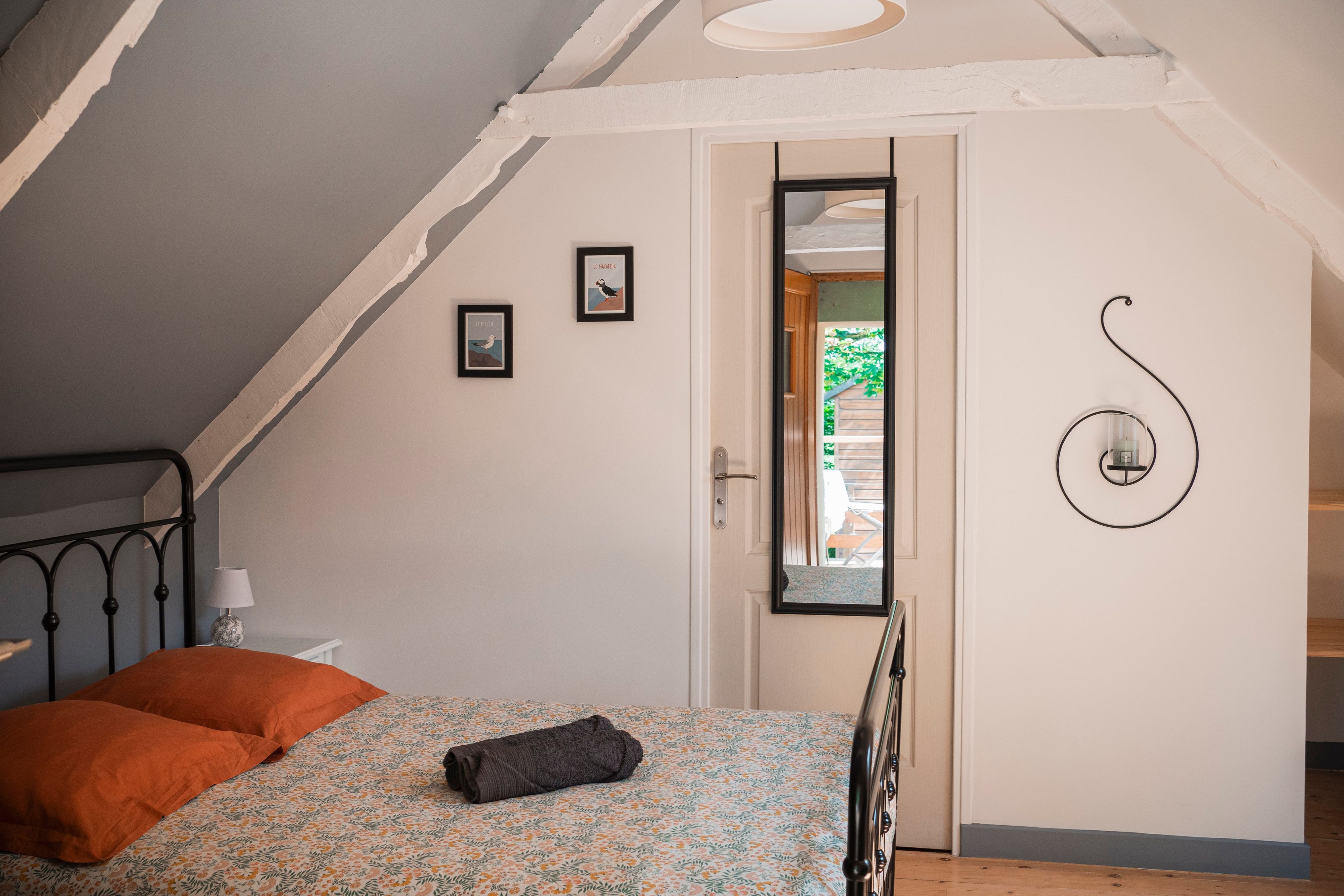 Ein Schlafzimmer mit einem Bett, einer Tür und einer Wandleuchte.