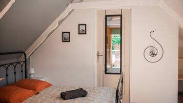 Ein Schlafzimmer mit einem Bett, einer Tür und einer Wandleuchte.