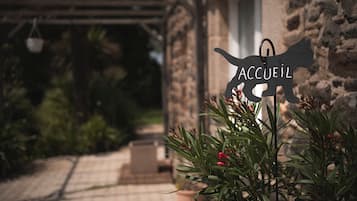 Un edificio in pietra con una segnaletica che riporta 'ACCUEL' e un vialetto che conduce all'ingresso.