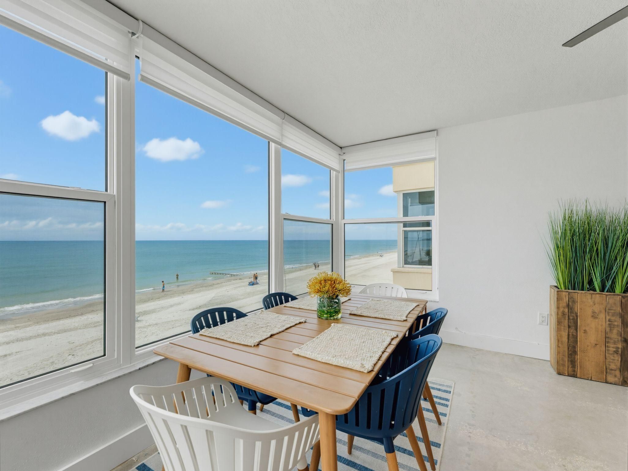 A dining area with a view of the beach and ocean.