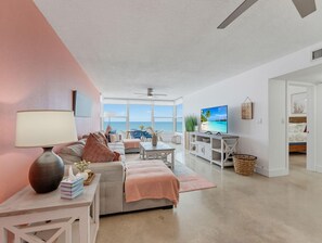 Een moderne woonkamer met een groot raam, een televisie en een gezellige zithoek.