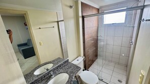 Een badkamer met twee wastafels, een toilet en een douche.