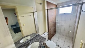 Un baño con dos lavabos, un inodoro y una ducha.