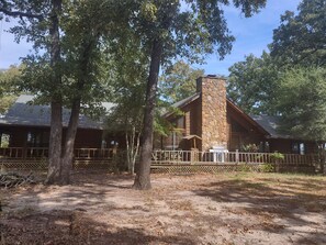 A log cabin with a stone chimney, surrounded by trees and a wooden fence. - Spacious 4-bedroom house in charming Athens with AC (Athens)
