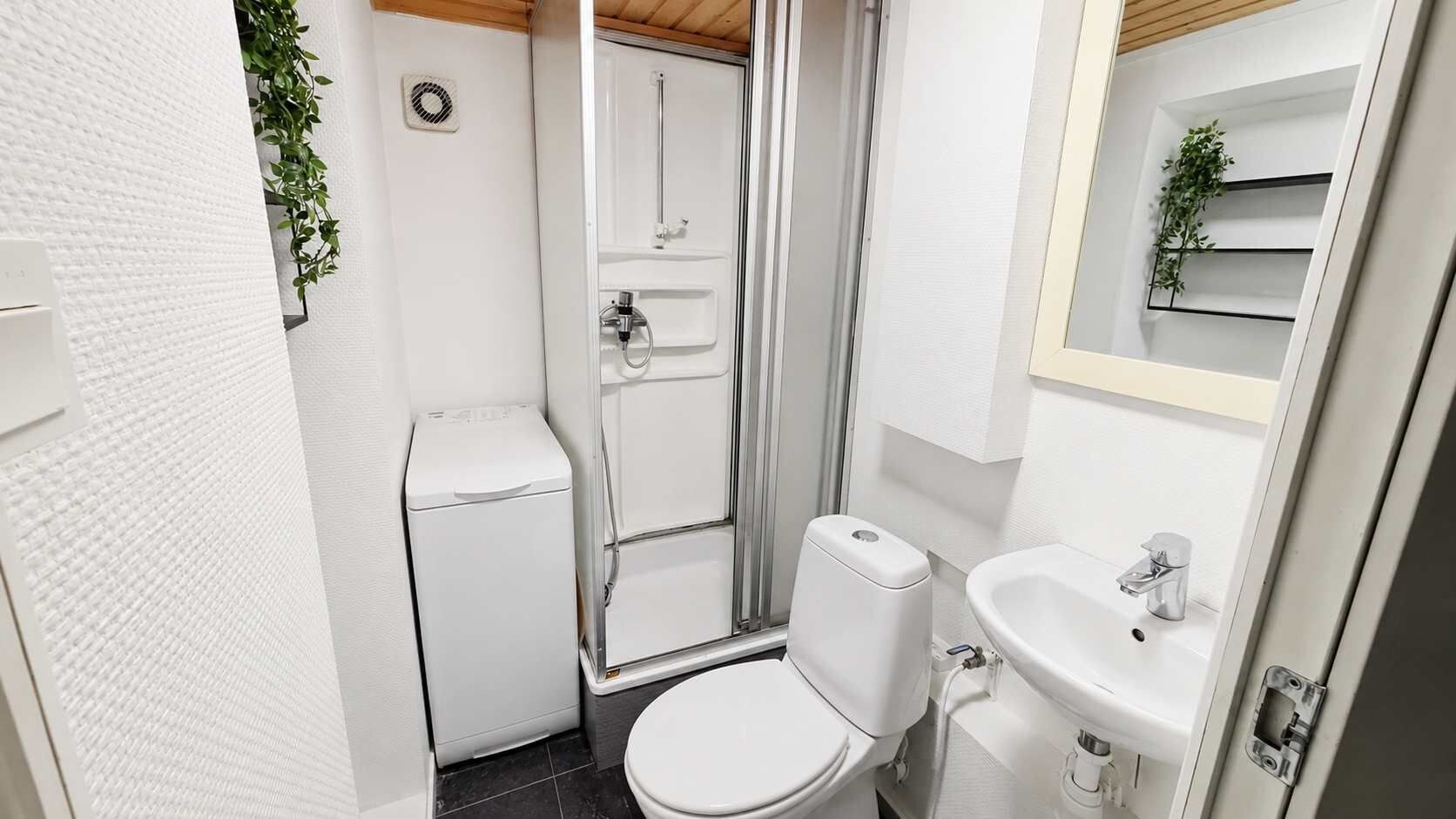 Ein kleines Badezimmer mit Toilette, Dusche und Waschbecken.