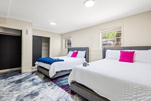 A hotel room with two beds, a wardrobe, and a window with a view. - Group Getaway- Theater Room + Game Room (Forest Park)