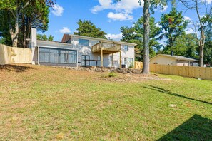 A two-story house with a covered porch and a garage. - Group Getaway- Theater Room + Game Room (Forest Park)