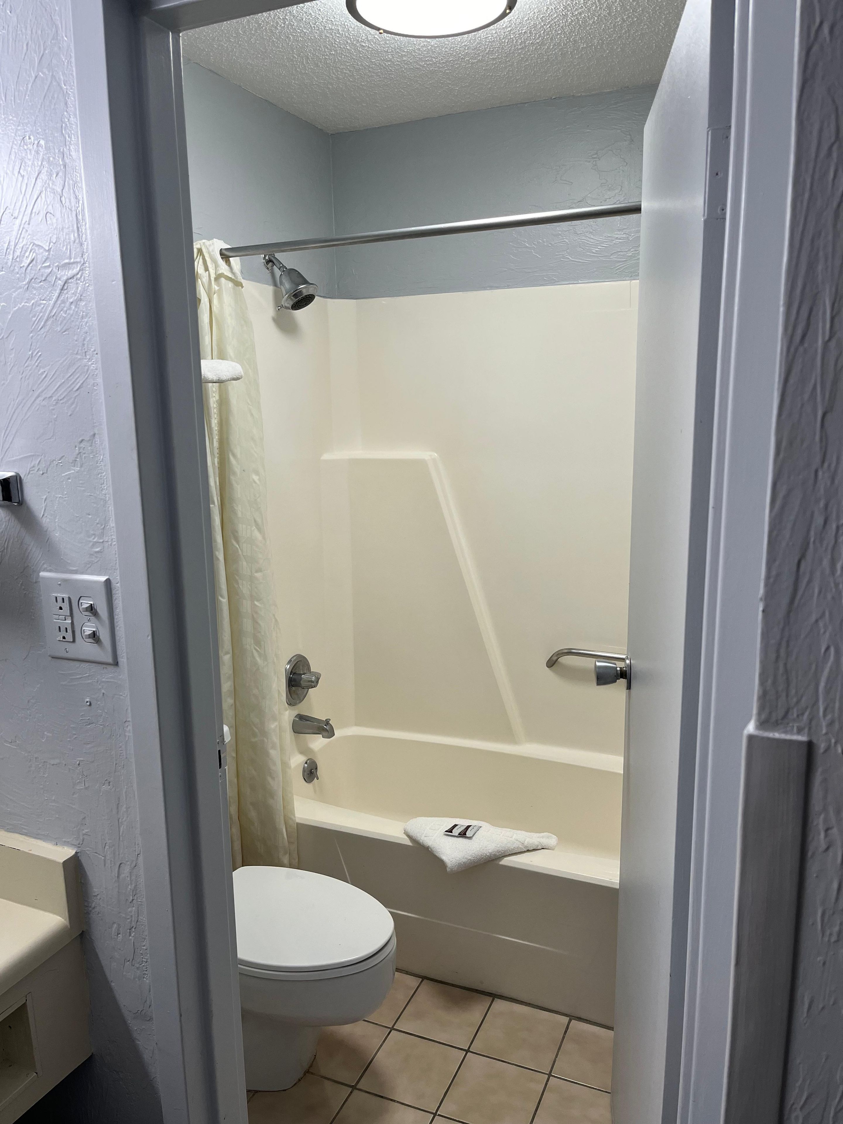 A bathroom with a toilet, a bathtub, and a shower.