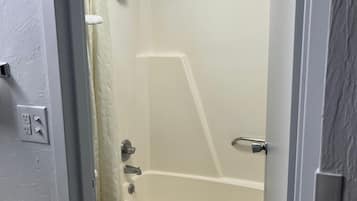 Une salle de bain avec des toilettes, une baignoire et une douche.