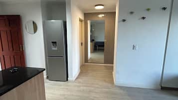 Una cocina con refrigerador, cubierta de madera y una puerta marcada con el número 30.