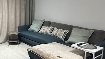 A modern living room with a sofa, a coffee table, and a side table.