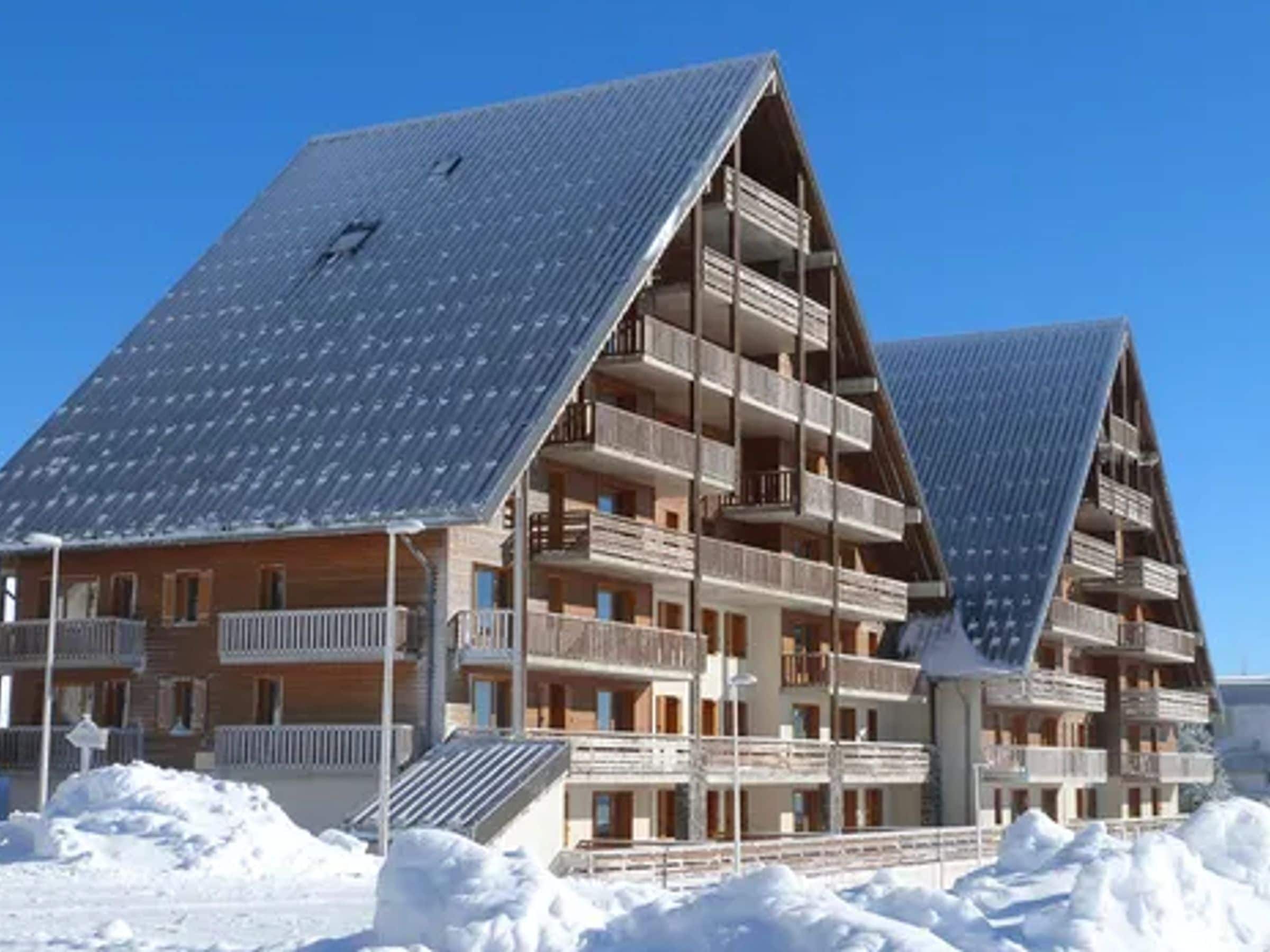 A multi-story hotel with balconies and a sloped roof.