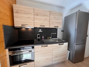 A modern kitchen with wooden cabinets, a stainless steel refrigerator, and built-in appliances. - Modern apartment - 4 guests (Vars)