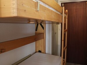 A bunk bed with a wooden headboard and a door to the right. - Bright studio - 4 guests, near ski lift (Saint-François-Longchamp)