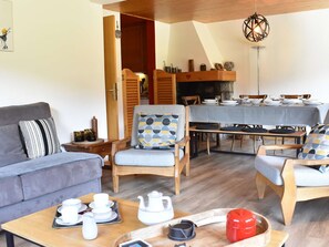 A cozy living area with a sofa, two armchairs, a coffee table, and a dining table set for four. - Bright apartment, panoramic view - 6 guests (Méribel)