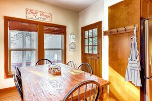 Un comedor con una mesa de madera, sillas, un refrigerador y un letrero que dice 'Soft Freeze'.