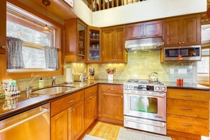 A kitchen with wooden cabinets, a stainless steel stove, and a microwave. - Beautiful 3BR Lakeview | 2 Living Rooms | Hot Tub (Soda Springs)