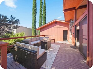 Eine Terrasse mit Gartenmöbeln, eine Steinmauer und ein Gebäude mit roter Fassade.